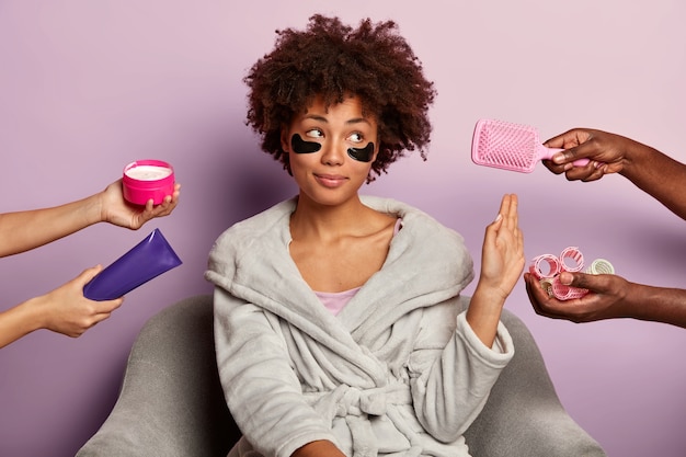 Photo gratuite calme jeune femme à la peau sombre fait un geste de refus, demande de ne pas donner de bigoudis