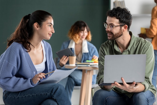 Photo gratuite camarades de classe lisant et apprenant à partir d'internet et de notes