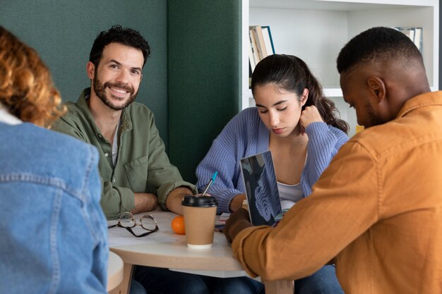 Camarades de classe lisant et apprenant à partir de notes et d'un ordinateur portable