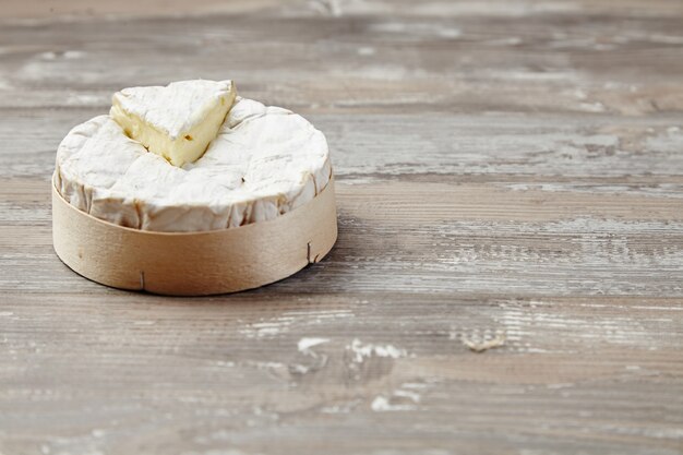 Camembert dans une boîte en bois sur table grunge