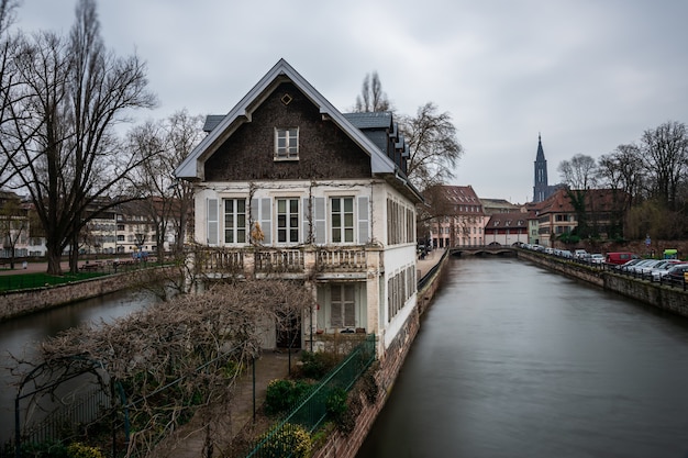 Canal entouré de bâtiments et de verdure sous un ciel nuageux à Strasbourg en France