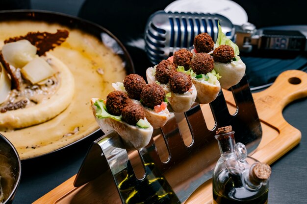 Canapés avec salade de boulettes de viande de style turc sur planche de bois tomate concombre vue latérale