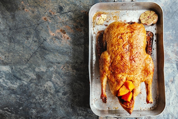 Canard rôti au four avec des légumes sur une poêle sur fond de pierre. Vue de dessus.