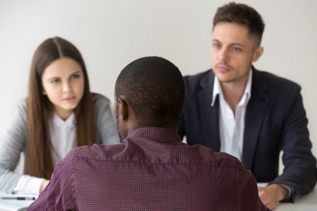 Photo gratuite candidat africain répondant à une question lors d'un entretien d'embauche, vue arrière