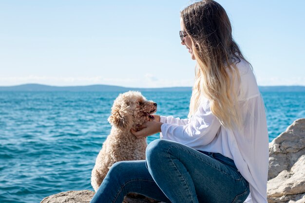 Caniche grand angle avec propriétaire au bord de mer