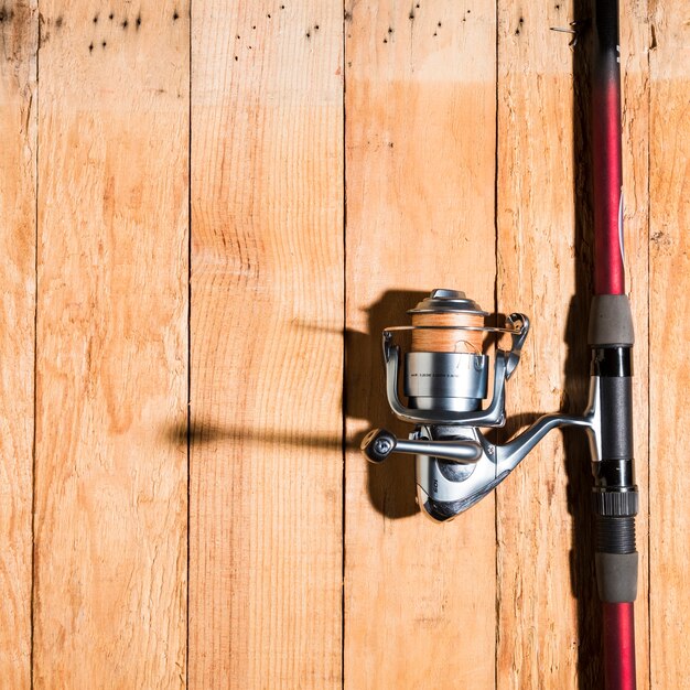 Canne à pêche avec moulinet sur un bureau en bois
