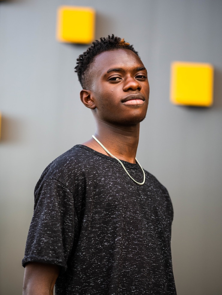 Photo gratuit capture d'écran peu profonde d'un jeune homme noir sur un mur gris