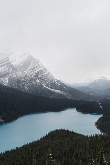 Capture en grand angle d'un lac gelé clair entouré d'un paysage montagneux