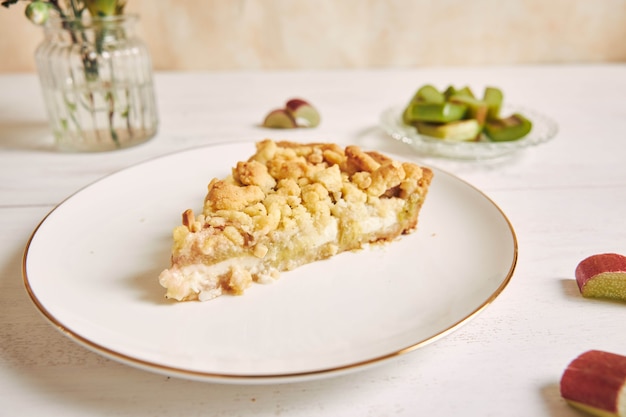 Capture en grand angle d'une tranche de tarte au gâteau Rhabarbar croustillante avec quelques ingrédients sur une table