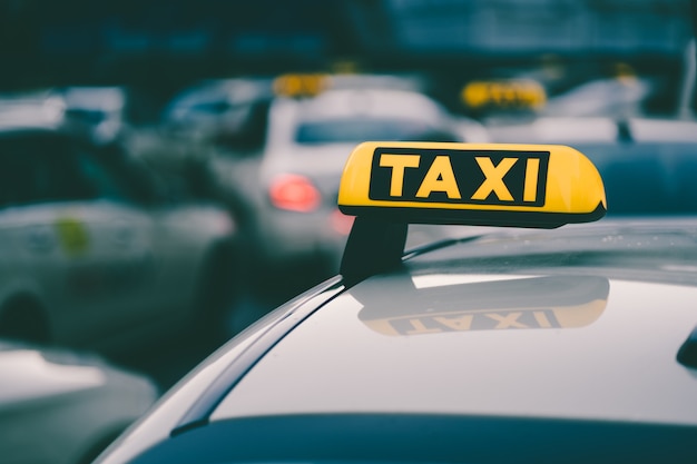 Capture de mise au point sélective d'un signe de taxi jaune dans un embouteillage