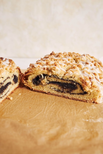 Capture verticale d'un délicieux gâteau aux graines de pavot avec un glaçage au sucre blanc sur une table blanche