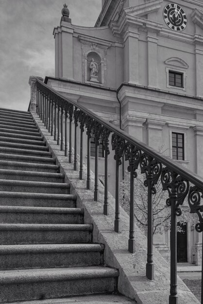 Capture verticale à faible angle de gris de l'escalier avec une belle balustrade menant au bâtiment historique