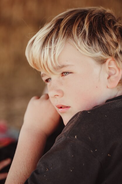 Photo gratuite capture verticale d'un garçon blond australien de race blanche regardant au loin