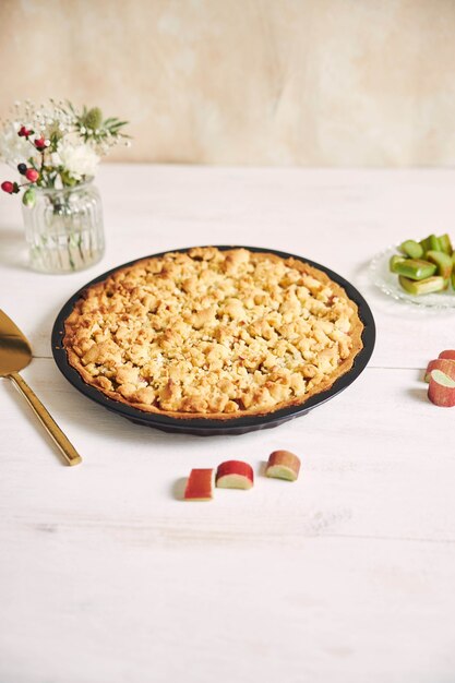 Capture verticale en grand angle d'une assiette de tarte au gâteau Rhabarbar croustillante et de quelques ingrédients sur une table