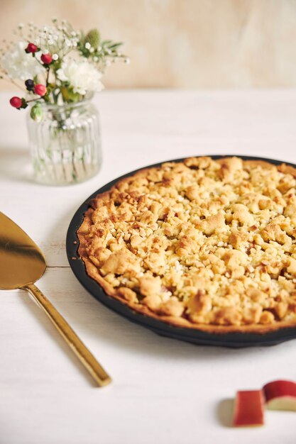 Capture verticale en grand angle d'une assiette de tarte au gâteau Rhabarbar croustillante et de quelques ingrédients sur une table