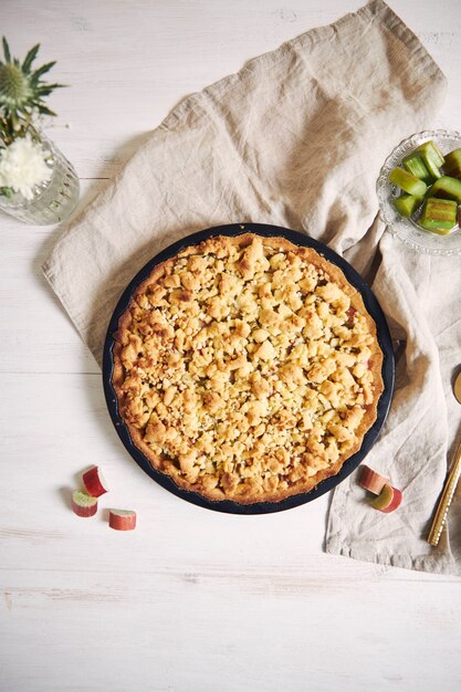 Capture verticale en grand angle d'une assiette de tarte au gâteau Rhabarbar croustillante et de quelques ingrédients sur une table