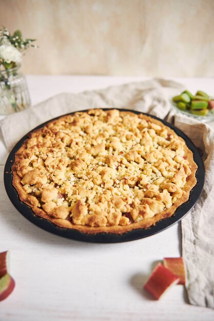 Capture verticale en grand angle d'une assiette de tarte au gâteau Rhabarbar croustillante et de quelques ingrédients sur une table