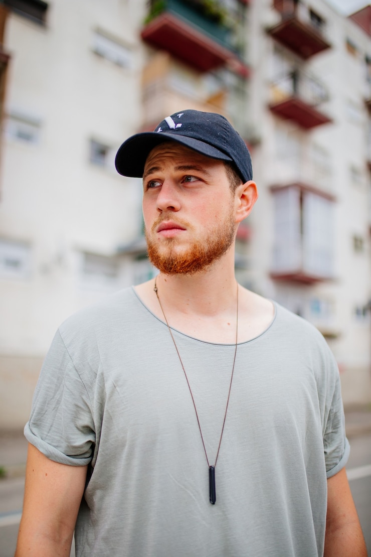 Photo gratuit capture verticale d'un homme de race blanche blond avec une barbe portant une casquette