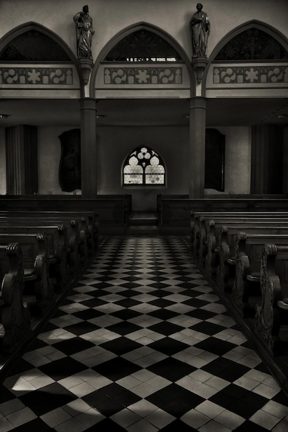 Photo gratuite capture verticale en niveaux de gris de l'intérieur d'une belle église historique prise du côté de l'autel