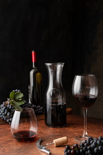 Photo gratuite carafe et verre à vin rouge sur assortiment de table