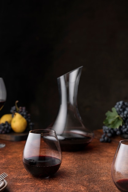 Photo gratuite carafe et verre à vin rouge sur table