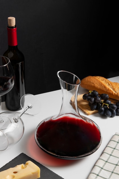 Photo gratuite carafe à vin rouge et raisins sur table