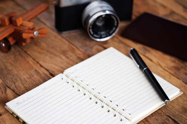 Carnet de notes et articles de voyage sur table en bois.