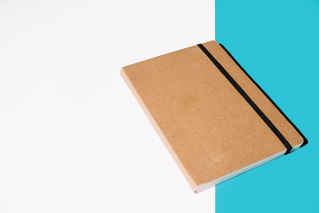 Carnet de notes à couverture brune sur fond blanc et bleu