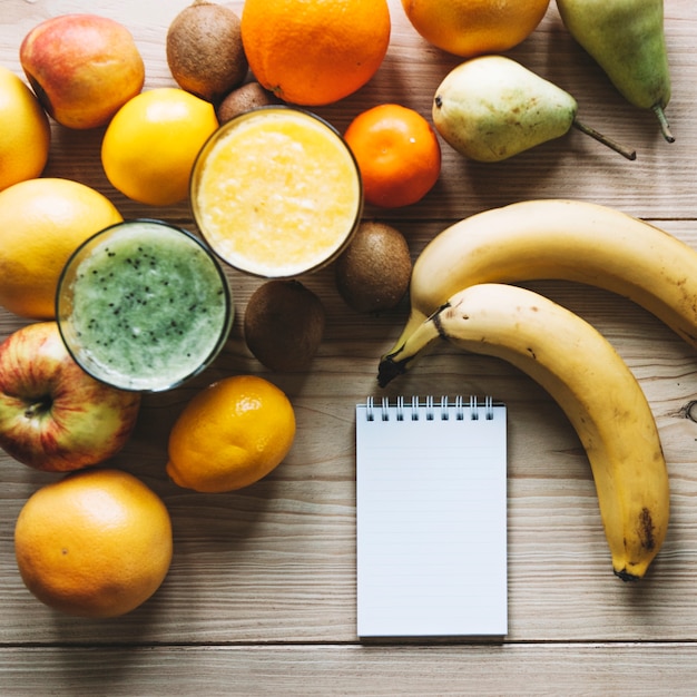 Photo gratuite carnet de notes près de fruits et smoothies