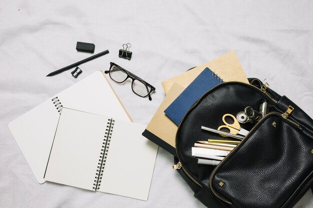 Carnets de croquis vierges et sac avec fournitures de bureau