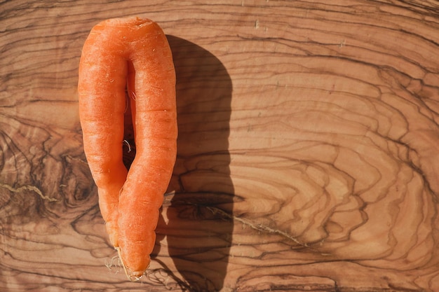 Carottes biologiques fraîchement cueillies de la ferme sur une planche à découper en bois lumière du soleil vue de dessus avec copie espace préparer un plat