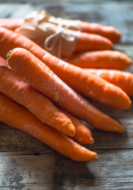 Carottes biologiques fraîches, un tas de carottes allongé sur des planches en bois