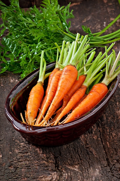 Carottes fraîches sur une vieille surface en bois