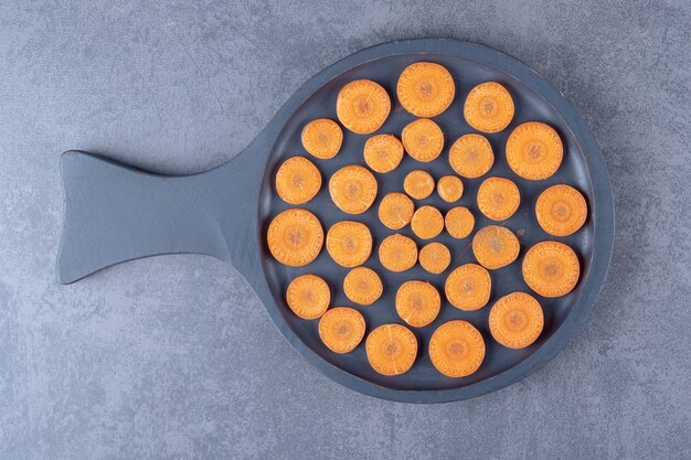 Carottes tranchées dans une poêle, sur la surface en marbre.