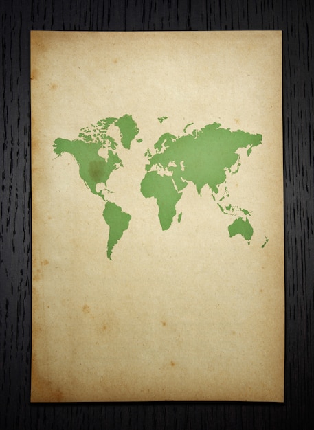 Carte du monde vintage sur fond de bois sombre avec tracé de découpage