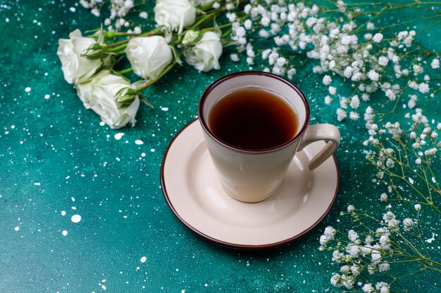 Carte de la journée de la femme du 8 mars avec des fleurs blanches, des bonbons et une tasse de thé