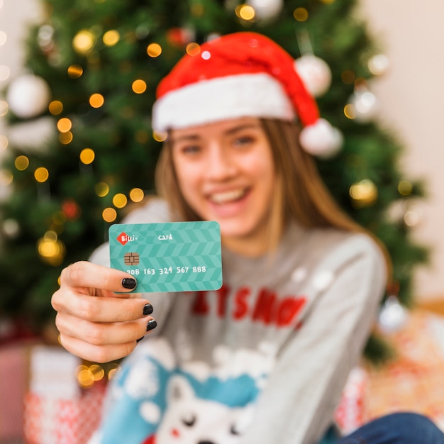 Carte montrée par une femme au chapeau de Noël