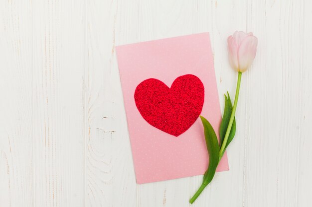 Carte de Saint Valentin avec des fleurs sur une table en bois blanche