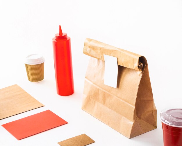 Carte vierge avec une tasse de café; bouteille de sauce; et paquet sur fond blanc