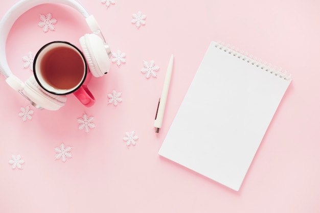 Casque et boisson à proximité des flocons de neige et du bloc-notes