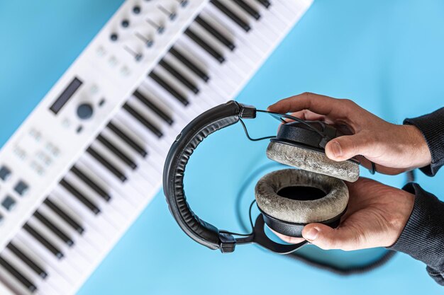 Casque dans les mains des hommes dans le contexte de la vue de dessus des touches musicales