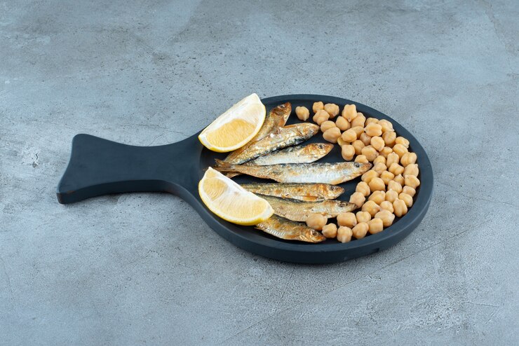 Photo gratuit une casserole sombre avec du poisson et des pois sur fond gris. photo de haute qualité