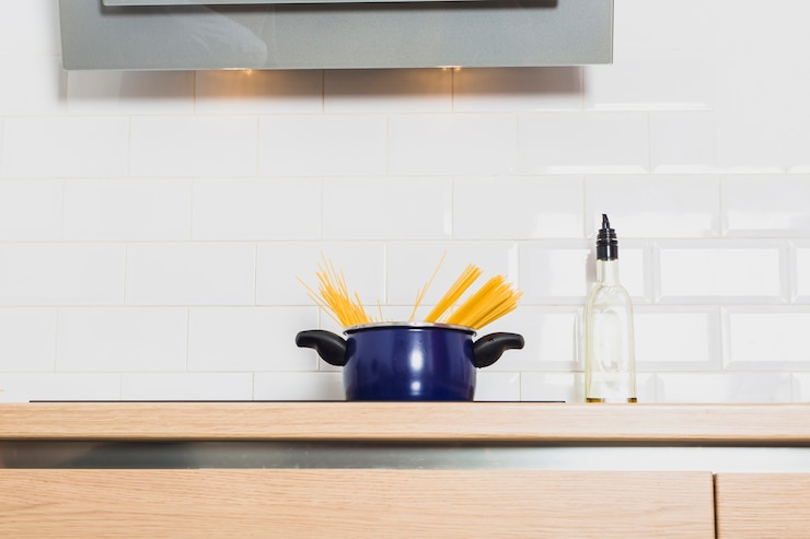 Photo gratuit casserole sur la table de cuisson dans la cuisine avec une bouteille d&#39;huile