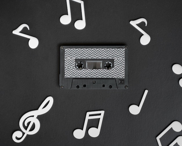 Cassette audio sombre entourée de notes de musique blanches