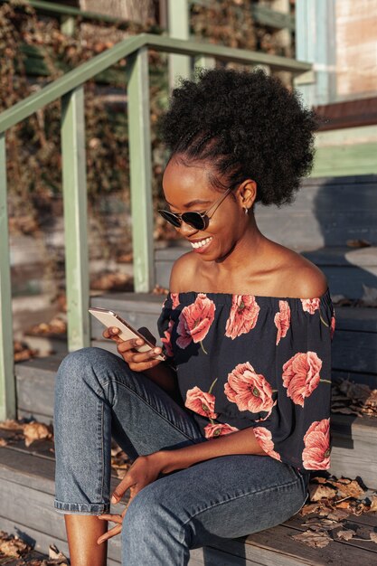 Casual femme africaine à la recherche sur son téléphone