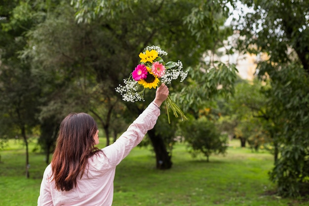 Casual femme avec des fleurs dans un parc verdoyant