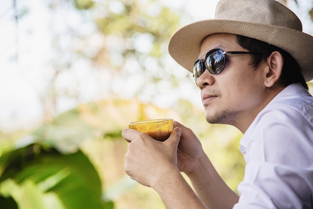 Casual homme asiatique boire un café chaud dans la nature