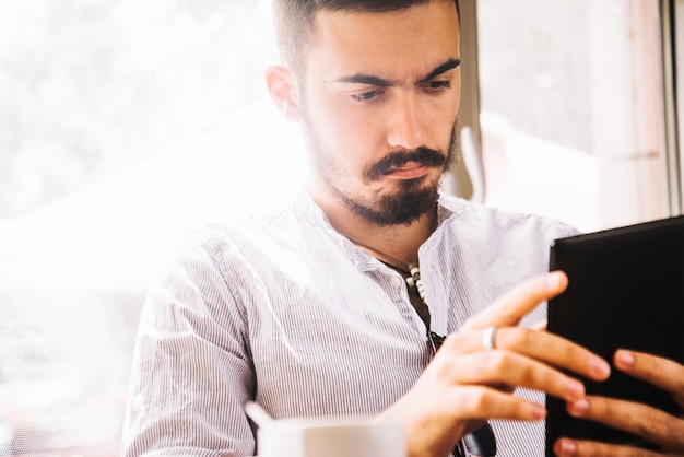 Casual jeune homme en regardant un smartphone