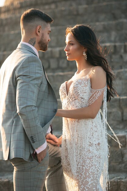 Caucasien jeune couple romantique célébrant leur mariage en ville. Tendre mariée et le marié sur la rue de la ville moderne. Famille, relation, concept d'amour