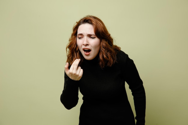 Caughing avec les yeux fermés jeune femme malade isolée sur fond vert